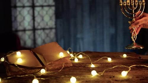 Hanukkah Menorah Lighting Next to Open Book