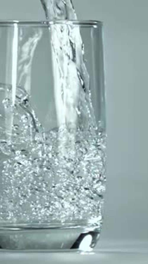 Se vierte agua en un vaso filmado con una cámara de alta velocidad a 1000 fps