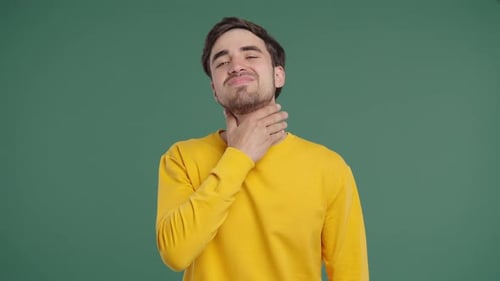 Young Man Has Sore Sick Guy With Swollen Throat On Green Studio Angina Pain