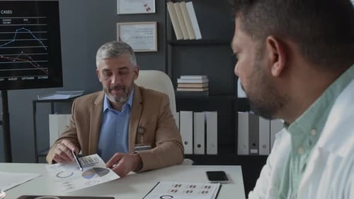 Men Discussing Medical Data in Office Setting