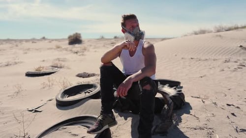 A Lone Man in a Respirator Mask Stands in a Vast Desert Isolated in a Postapocalyptic Scene