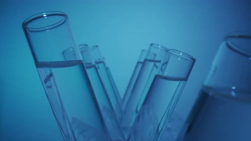 Close Up Video Neon Blue Light Test Tubes Filled with Fluid in a Laboratory Scientific Experiment