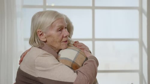 Women Embracing Affectionately in Brightly Lit Room