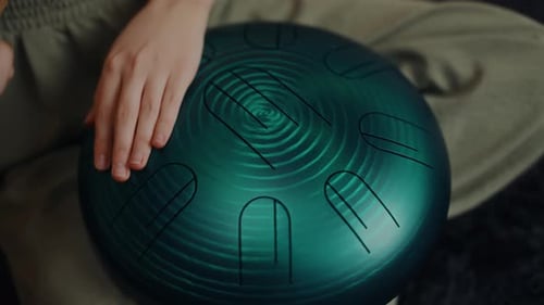 Hand Playing Steel Tongue Drum Closeup in Wellness Setting