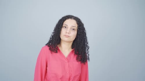 Young woman looking at camera with curious expression.