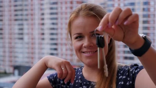 A Woman with the Keys to a New Apartment on the Balcony of a Residential Complex