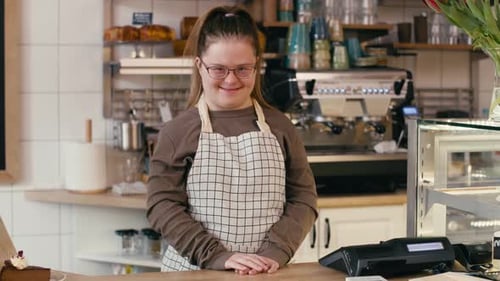 Portrait of down syndrome girl as a worker in the cafe. Shot with RED helium camera in 8K.