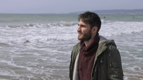 Depressed thoughtful young man walking alone on the beach.Thoughts,worries