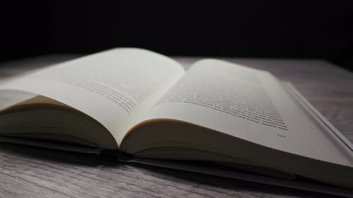 Book Pages Turning on Wooden Table in Studio