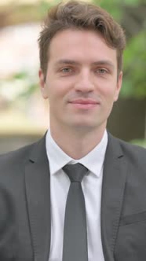 Man in Suit Giving Thumbs Up Outside