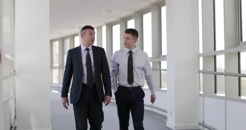 Businessmen walking through office having a meeting