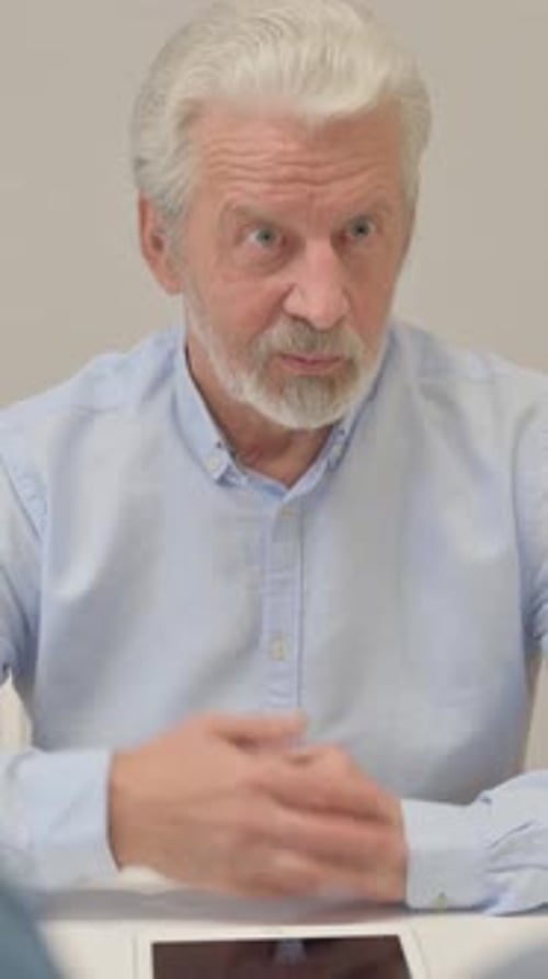 Senior man talking at a table close up