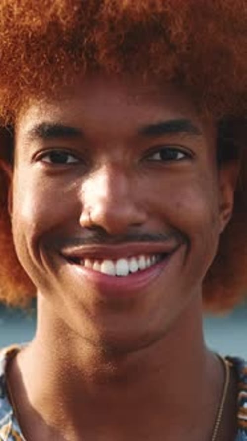 Close-up of happy man smiling at camera standing outside in street