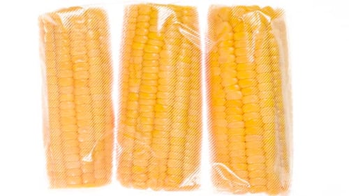 Three Packaged Corn Cobs on White