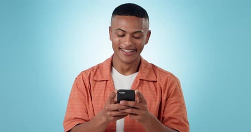 Phone, networking and young man in a studio typing a message on the internet or mobile app