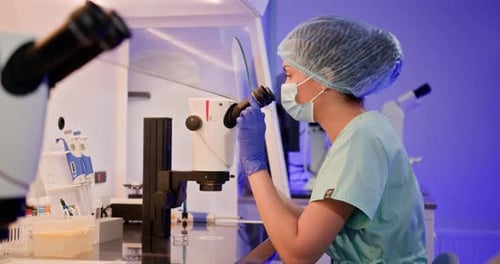 Portrait of a Female Embryologist Sitting in a Laboratory Near a Microscope