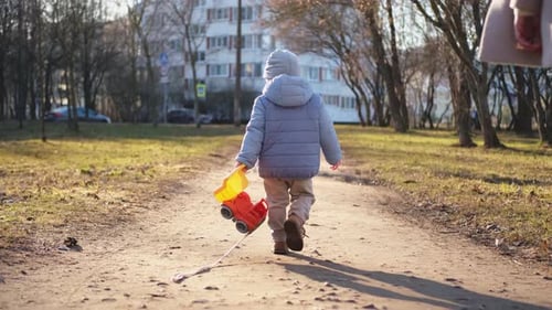 Happy Family Outdoor Back View of Mother and Her Child on Walk in Park Mom Walking Along Road with