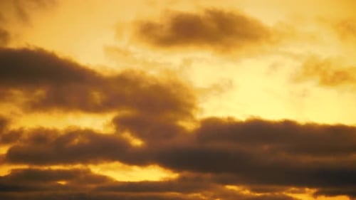 Timelapse of clouds passing by at sunset. Orange day