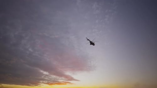 Militärischer Transporthubschrauber, der bei Sonnenuntergang oder Sonnenaufgang fliegt