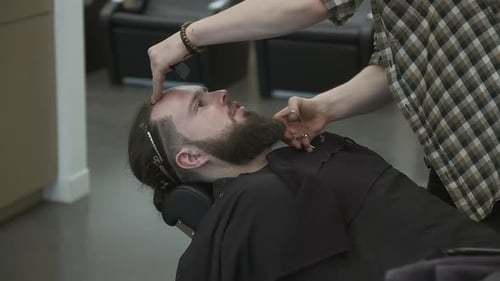 Barber Trimming Beard of Client in Barbershop