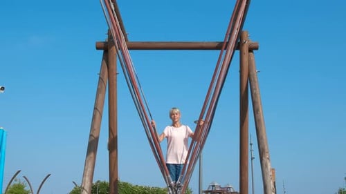 Teen Playing on Suspension Bridge in Park