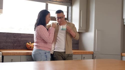 Couple Drinking Coffee and Talking in Kitchen