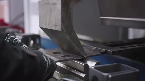 A Closeup Shot Shows a Worker's Hands at a Manufacturing Plant Bending Steel Parts on a Specialized