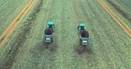 Luftaufnahme eines Traktors, der Dünger auf einem Feld sät