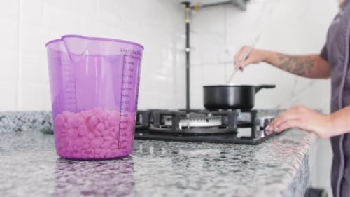 Woman Cooking in Kitchen with Purple Measuring Cup