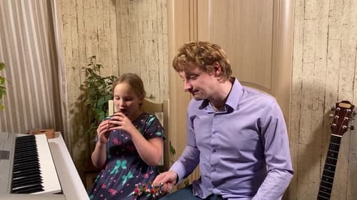 Child and Adult Playing Musical Instruments Indoors