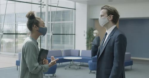 Business people office meeting in lobby wearing protective face mask and using digital tablet