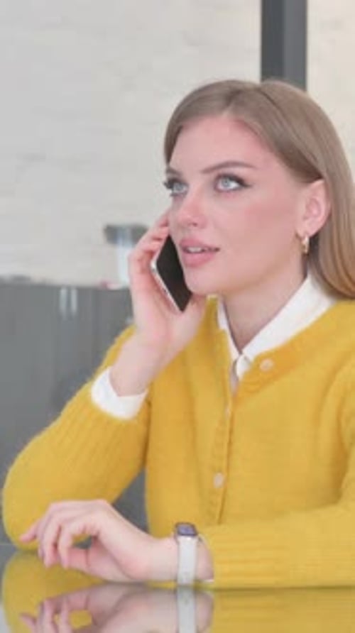 Young Woman in Yellow Sweater Talking on Phone