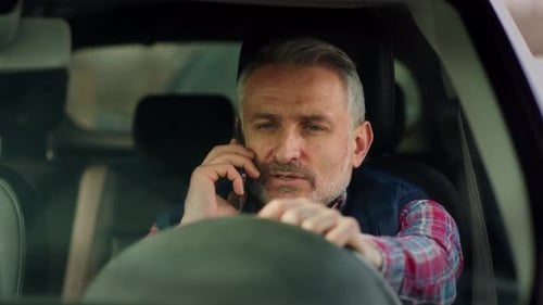 Man Talking Angrily on Phone in Car