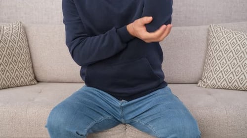 Man Massaging Elbow Due to Painful Injury