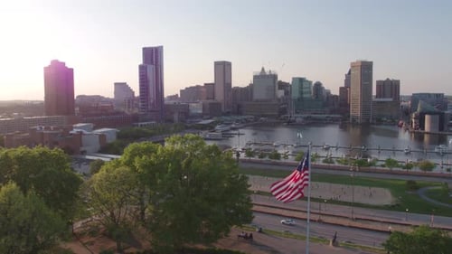 City Skyline and American Flag Waving on Breezy Day
