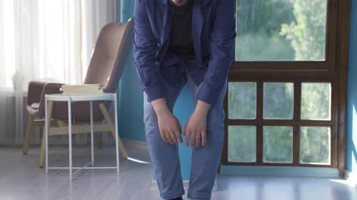 Young Man Sitting Sadly on the Floor