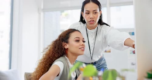 Two Women Collaborating on Computer in Modern Office