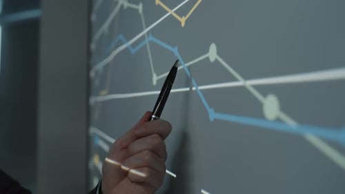 Hand of Businessman Pointing at Line Graph during Presentation