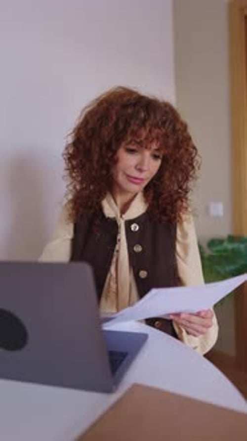 Focused Businesswoman Reviewing Important Documents at Her Desk