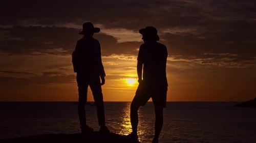Romantic Beach Scene at Dusk with Loving Couple Under Colorful Sky and Clouds