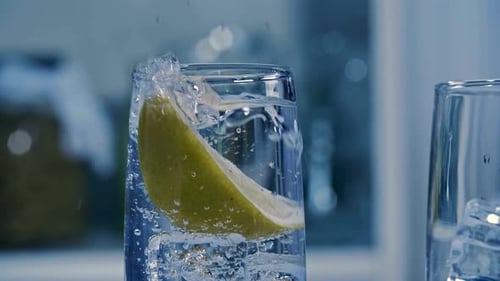 Lemon Wedge Plunges Into Glass of Sparkling Water