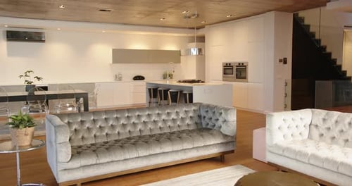 Modern living room with stylish furniture and open kitchen in contemporary home