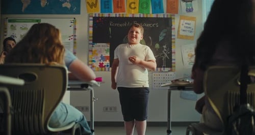 Shy Primary School Boy Showcasing Knowledge of Ecology in Front of Class Full of Kids in Classroom