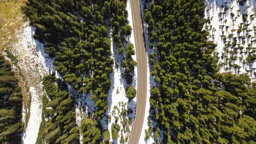 4K Aerial Drone Top Down view of road in snowy pine forest