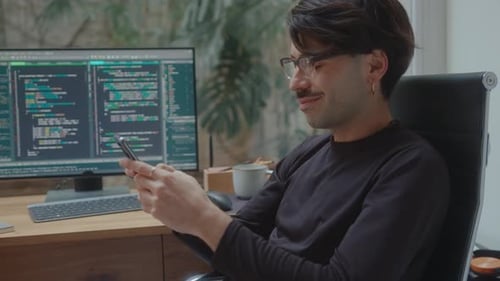 Programmer Messaging on Phone at Workplace in Home Office