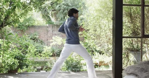 Caucasian man practicing yoga on terrace in sunny nature, slow motion