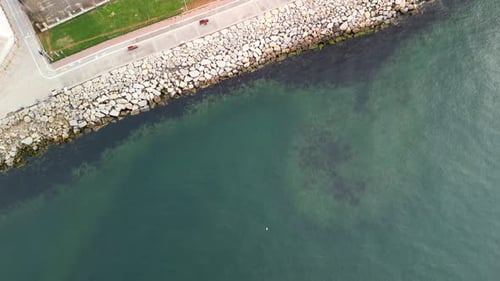 Big empty car parking lot by the seaside, drone reveal shot