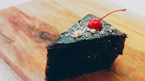 Slice of Chocolate Cake on Wooden Cutting Board