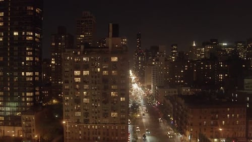night aerial shot of avenue street traffic and city buildings