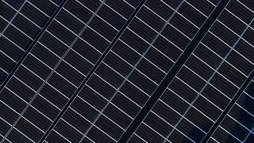 Aerial drone view of solar panels at sunset. Photovoltaics on top of the roof of the building. Alter